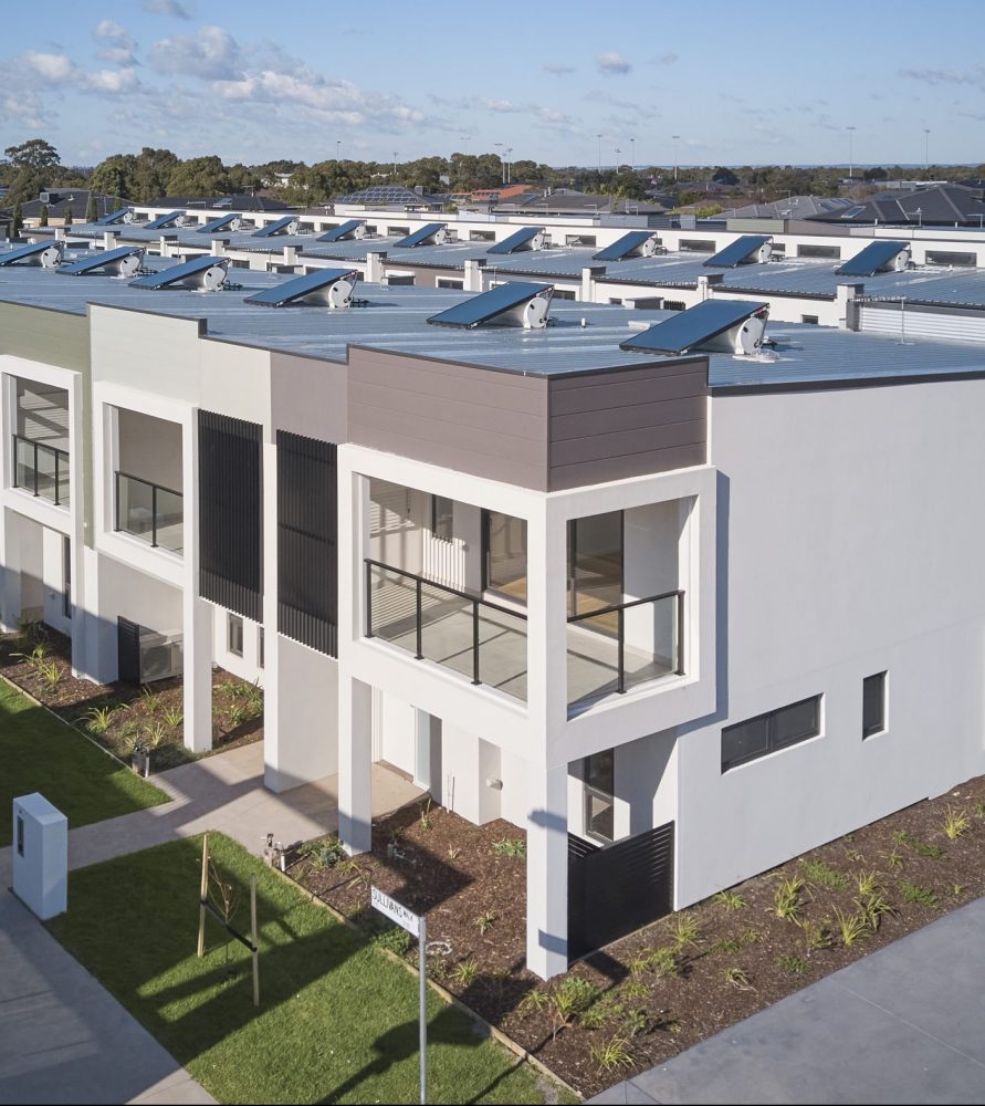 Drone image of body corporate townhouse estate with common gardens and driveway